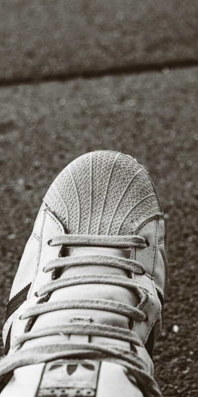 Detailed view of a sports shoe on concrete pavement. Focus on texture and design.