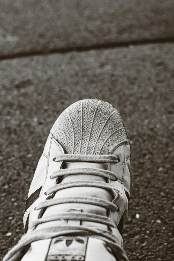 Detailed view of a sports shoe on concrete pavement. Focus on texture and design.