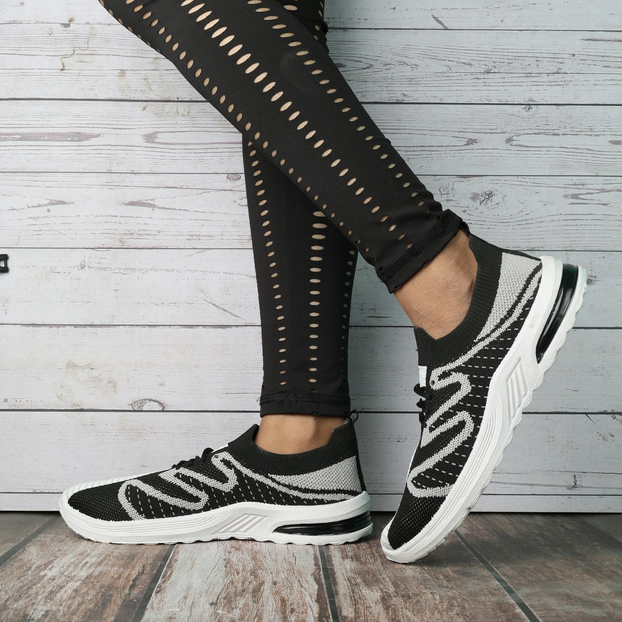 Fashionable black and white sneakers paired with trendy leggings, ideal for casual outings.