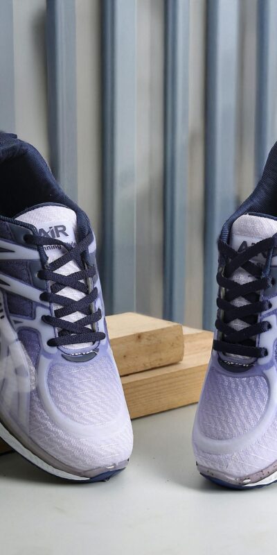 Stylish purple sports shoes displayed against a wooden and metal background in New Delhi.